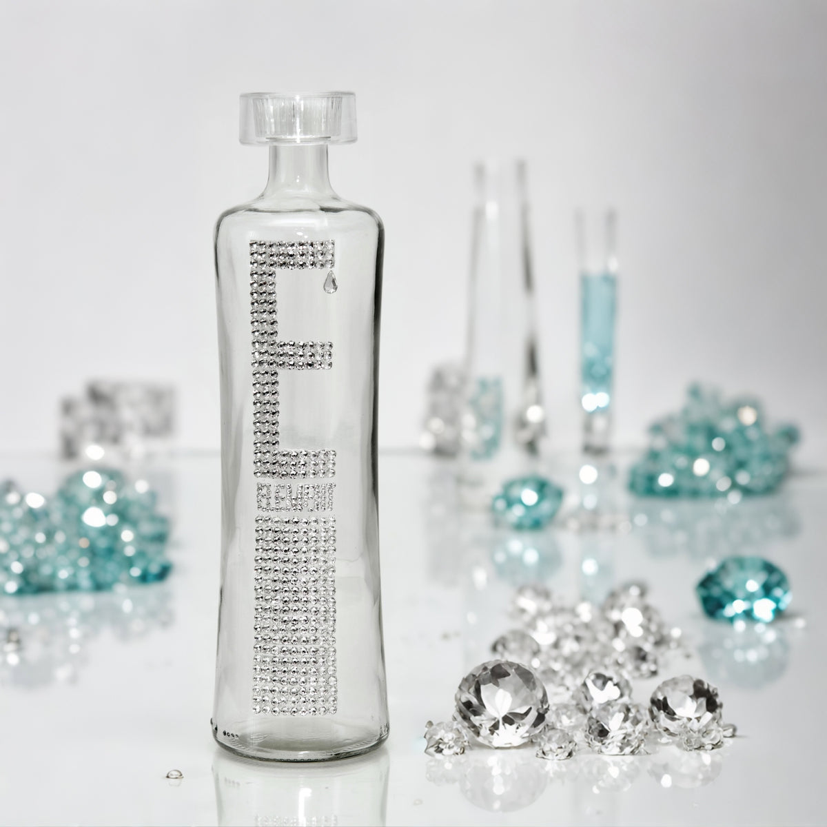 Element glass water bottle with clear crystals E letter and shiny T-shaped stopper in clear and blue scattered crystals setting