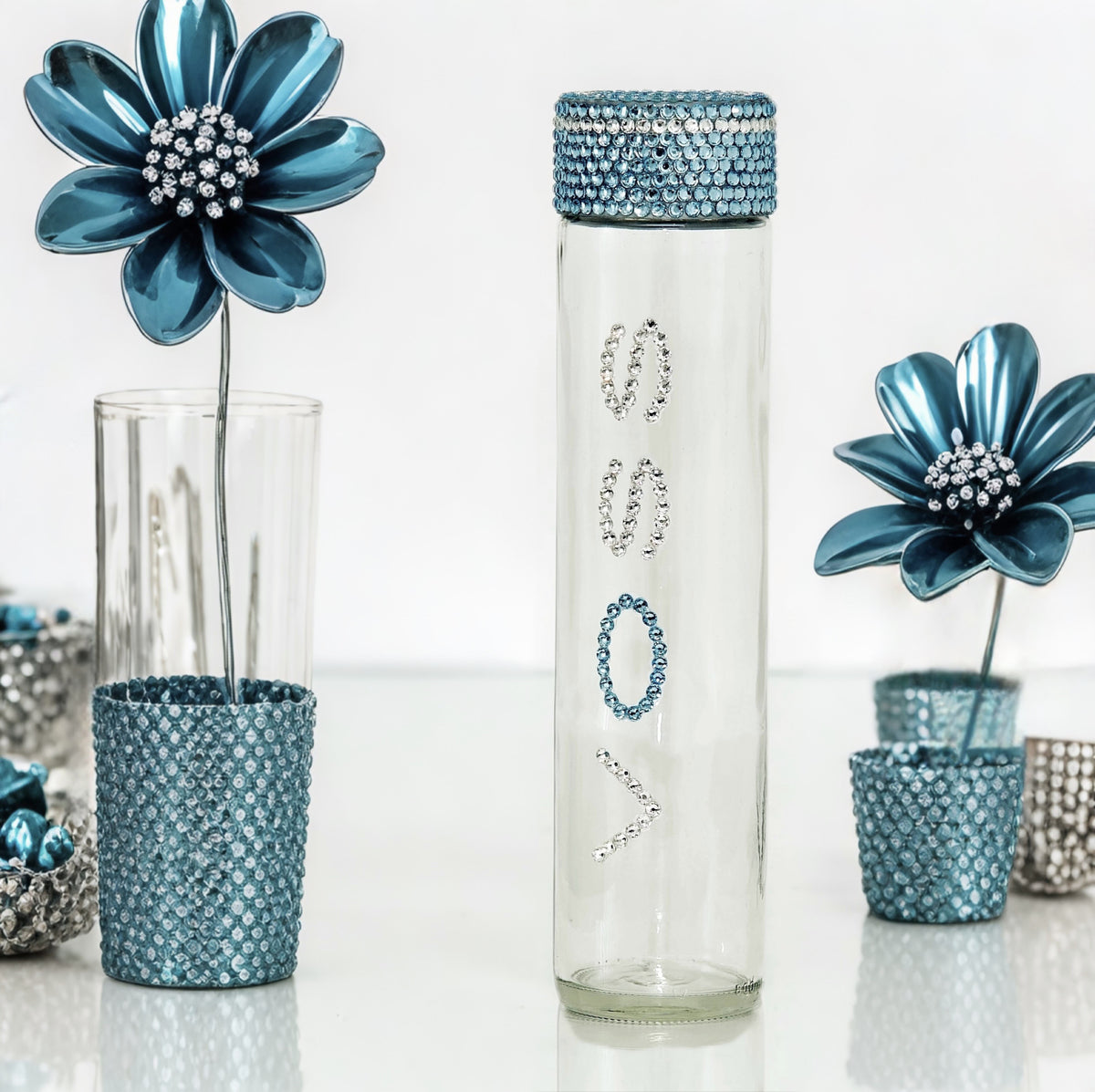 Voss glass water bottle with clear and blue crystals in blue floral glam setting