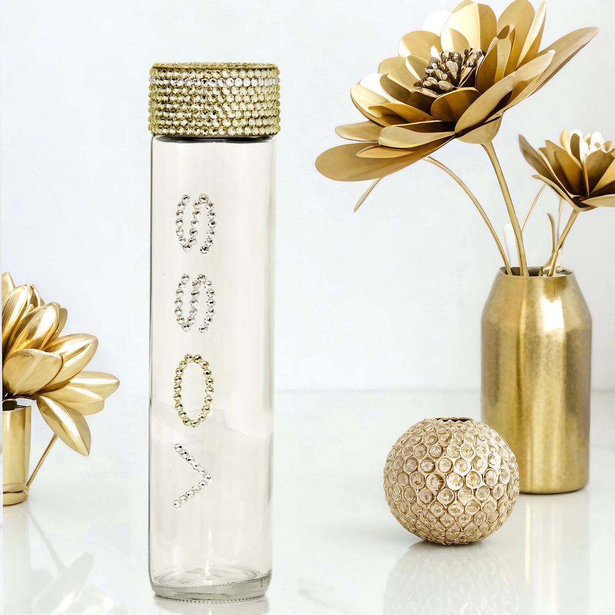 Voss glass water bottle with clear and gold crystals in gold floral glam setting