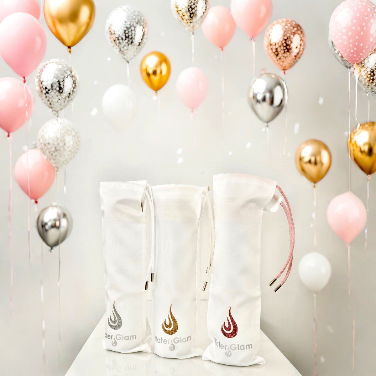 White Bottle bags with iconic silver, gold, pink glittering drop logo in balloon party setting